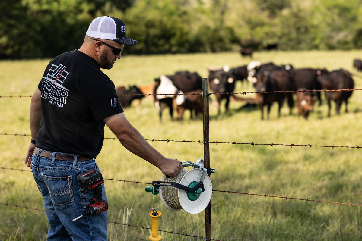 Utilizer poly wire reel holder mounted on a T-post for electric fence