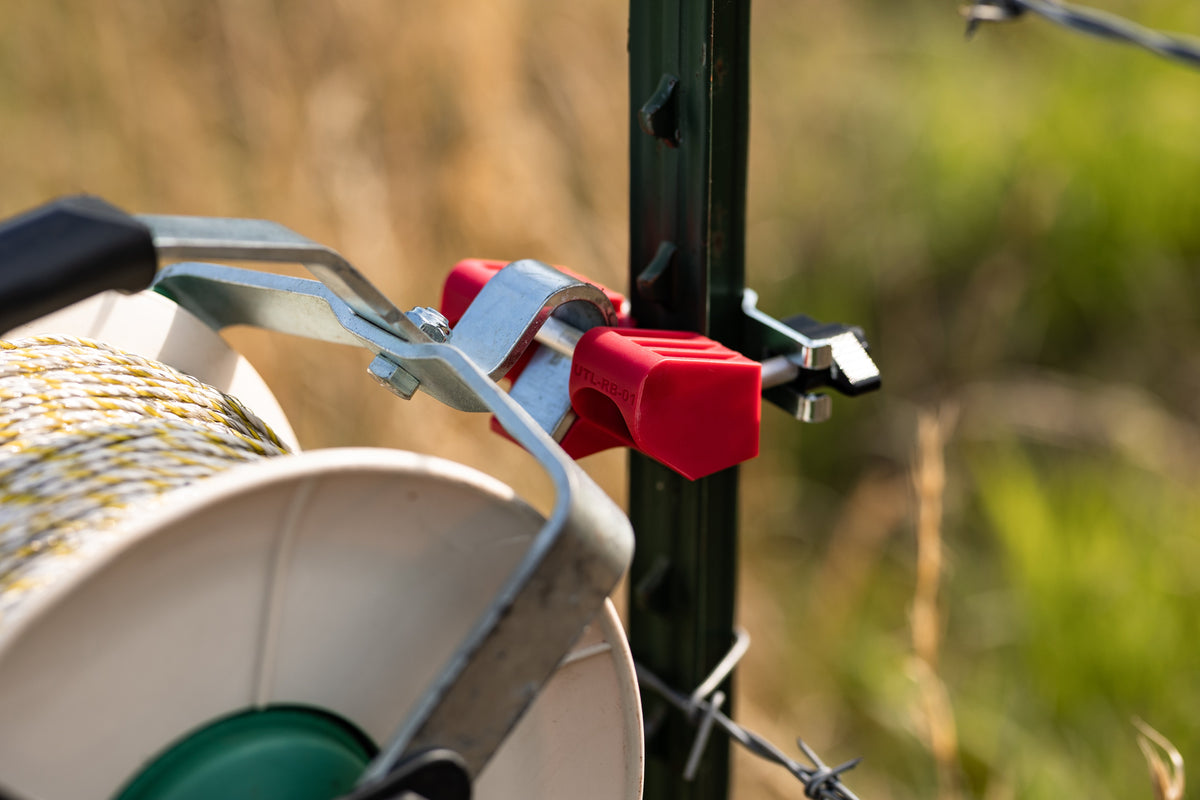 Utilizer red poly wire reel holder with a reel for electric fence