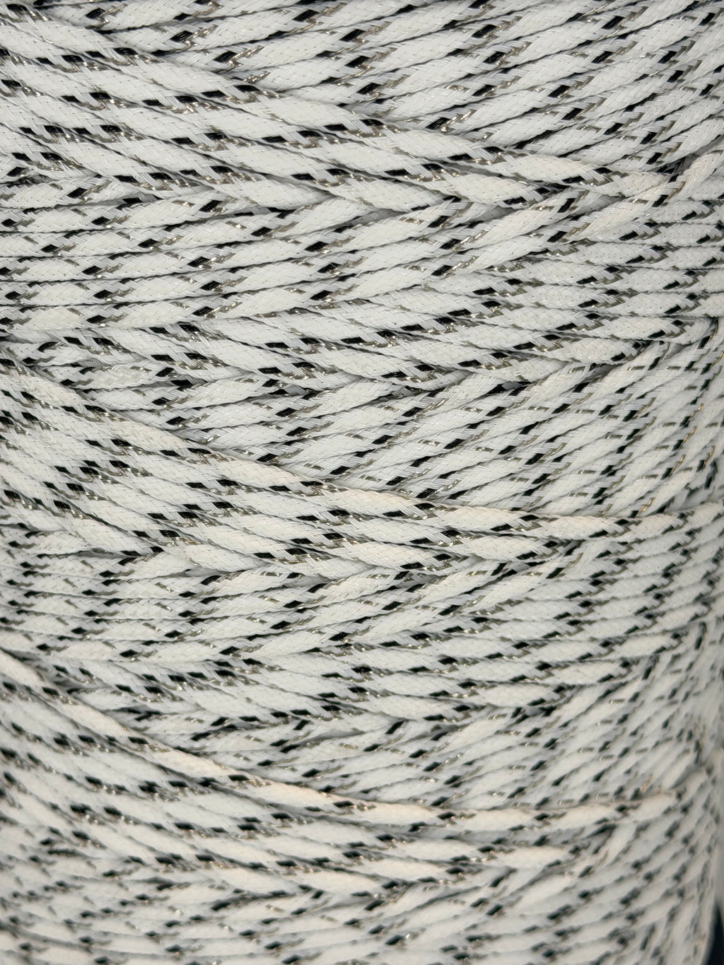 Close-up of a spool of gray and white yarn